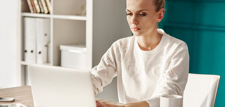 serious woman with laptop working at home office